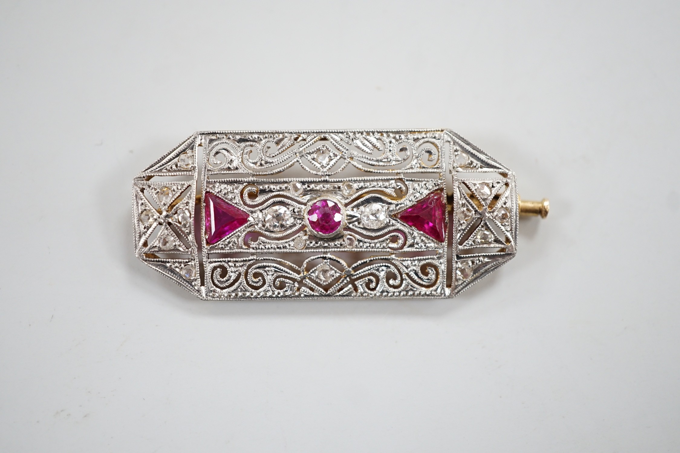 An Edwardian style, pierced white and yellow metal, diamond and three red stone set octagonal brooch, 41mm, gross weight 7.4 grams.